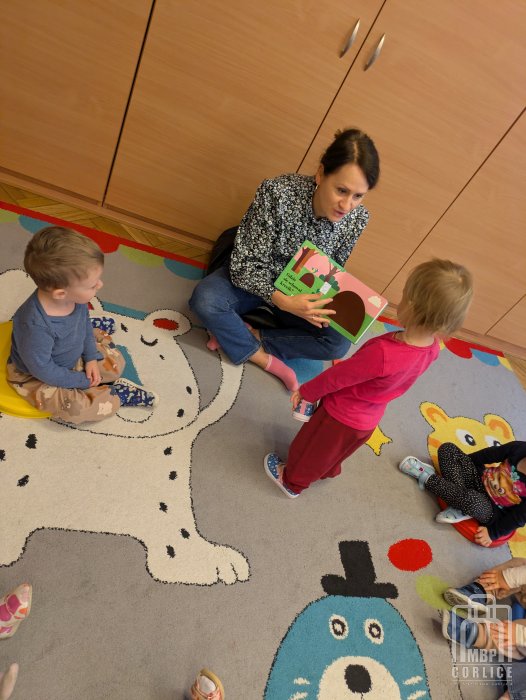 Biblioteka Gorlice, Pierwsze kroki… w świecie książek dziecko otwiera okienko w książce, którą czyta bibliotekarka